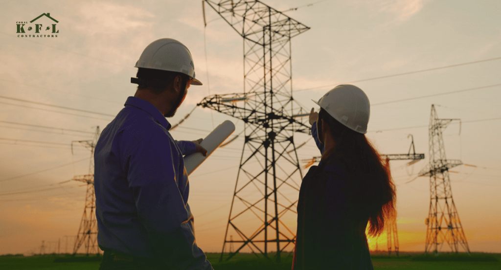 Engineers inspecting power lines during sunset representing commercial electrical services by KFL Contractors.